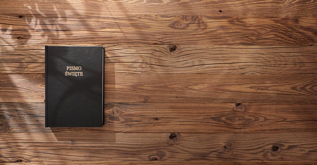 Polish Bible on a wooden table, sunlight and shadows creating a serene atmosphere.